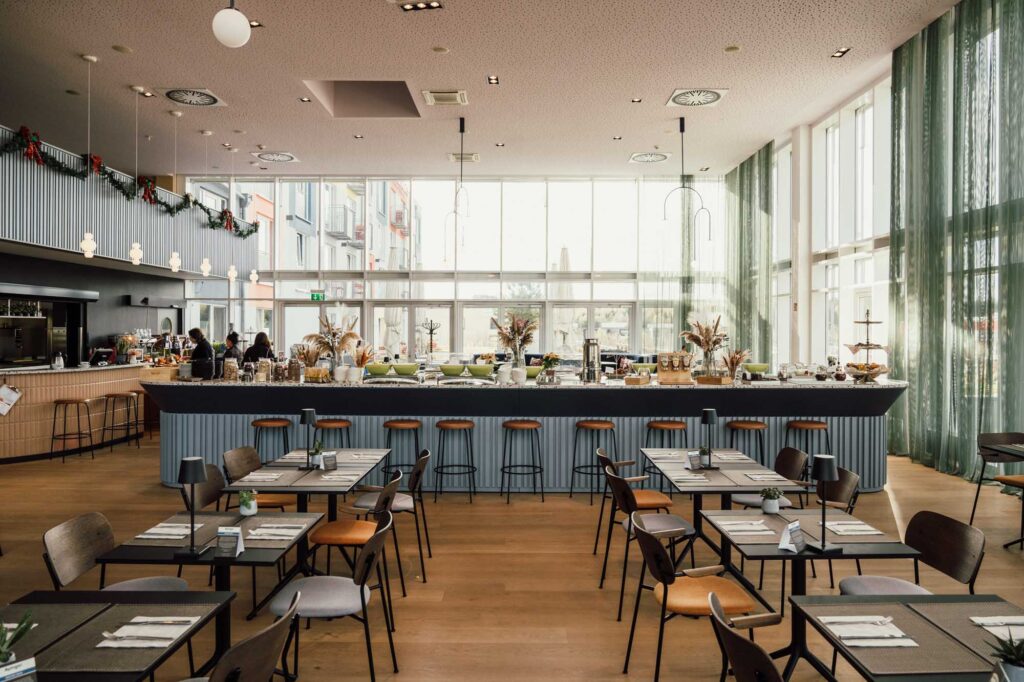 Ein moderner Speisesaal mit mehreren Tischen und einer Buffet-Theke